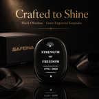Black obsidian Strength of Freedom keepsake held in hand showing thin flat shape and approx. 40×30mm size
